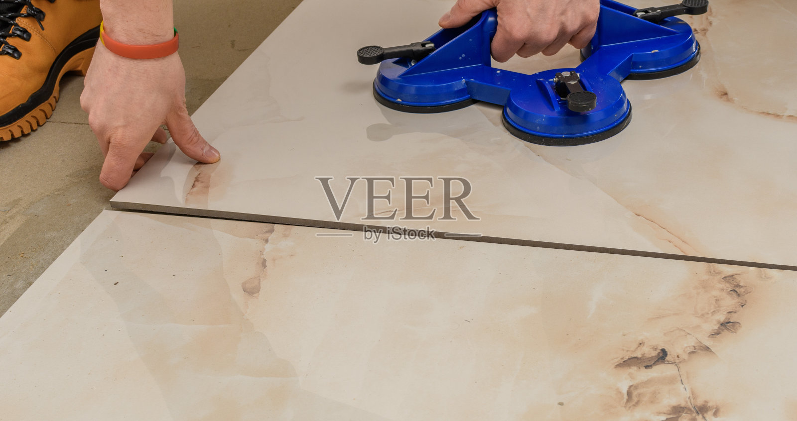 铺设地砖的近景，施工中的体力劳动照片摄影图片
