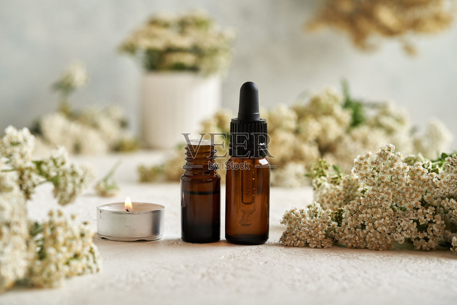棕色瓶子芳香疗法精油与新鲜盛开的蓍草照片摄影图片