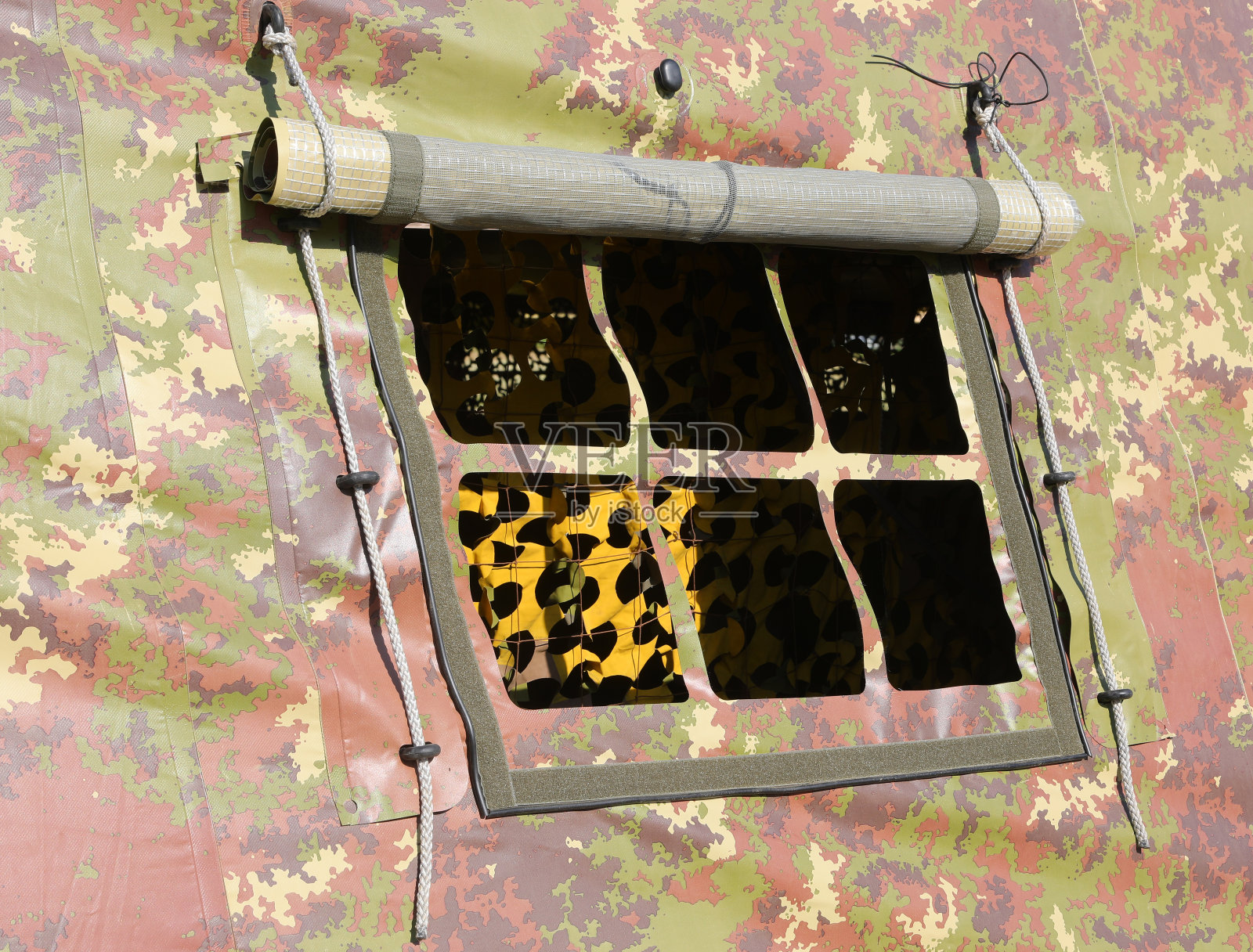 战争期间训练营中带有迷彩织物的军用帐篷的小窗户细节照片摄影图片