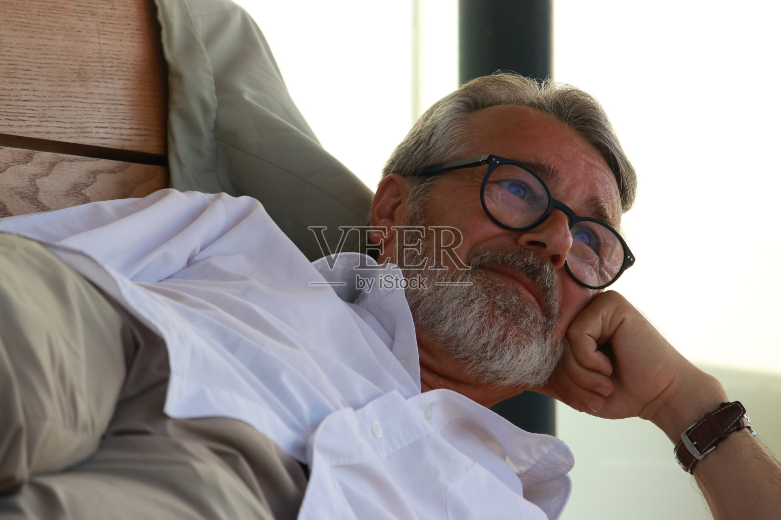 老人在长凳上休息等车照片摄影图片