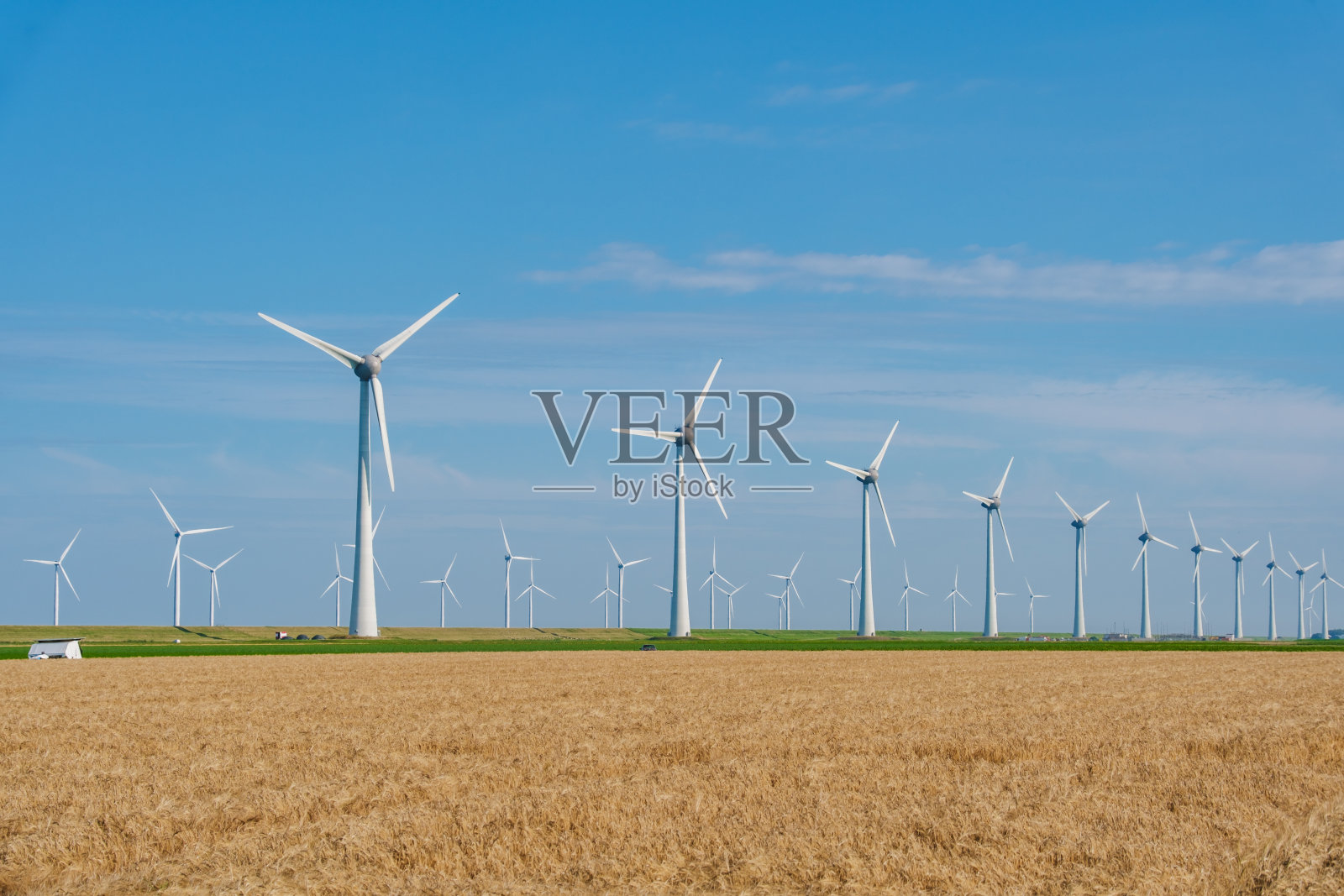 荷兰明亮的天空下，风力涡轮机产生可再生能源照片摄影图片