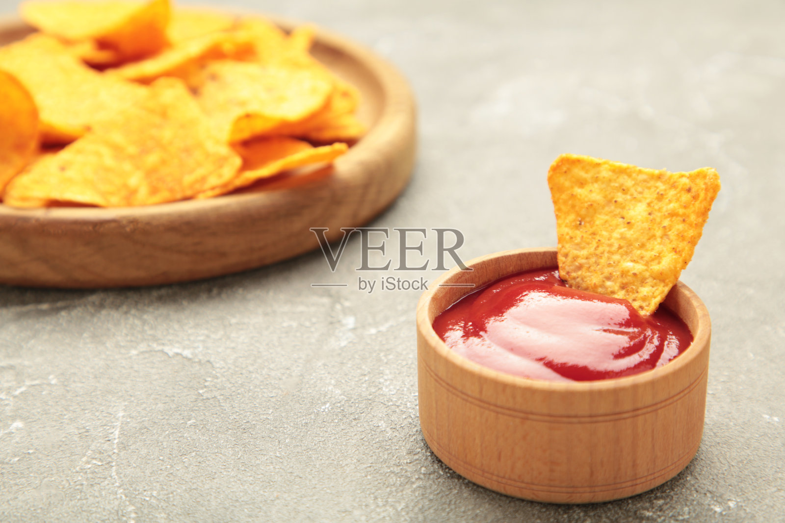 碗里的玉米片配上灰色背景的番茄酱。墨西哥菜。俯视图照片摄影图片