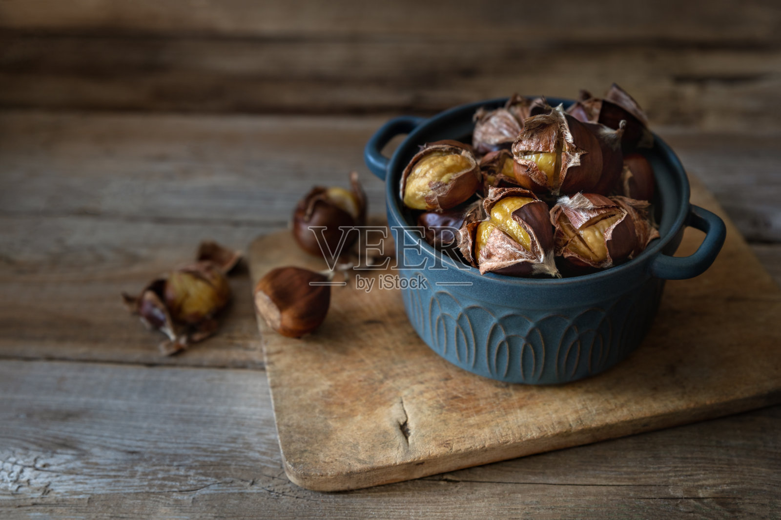 木桌上的烤栗子裹着皮照片摄影图片