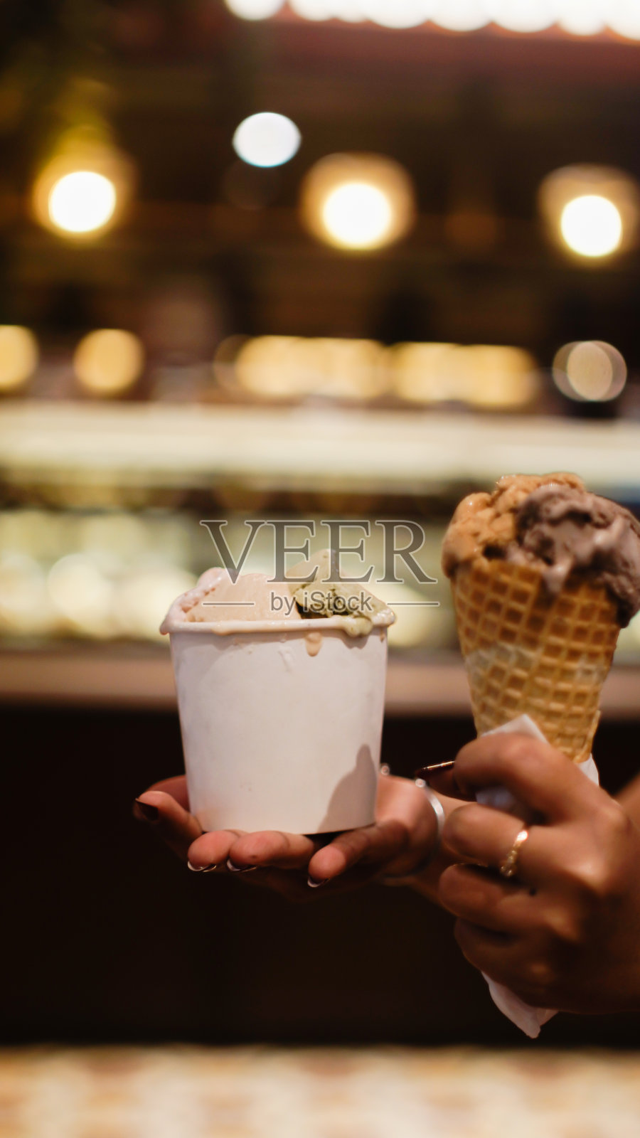 手里拿着一个杯子和一筒冰淇淋照片摄影图片