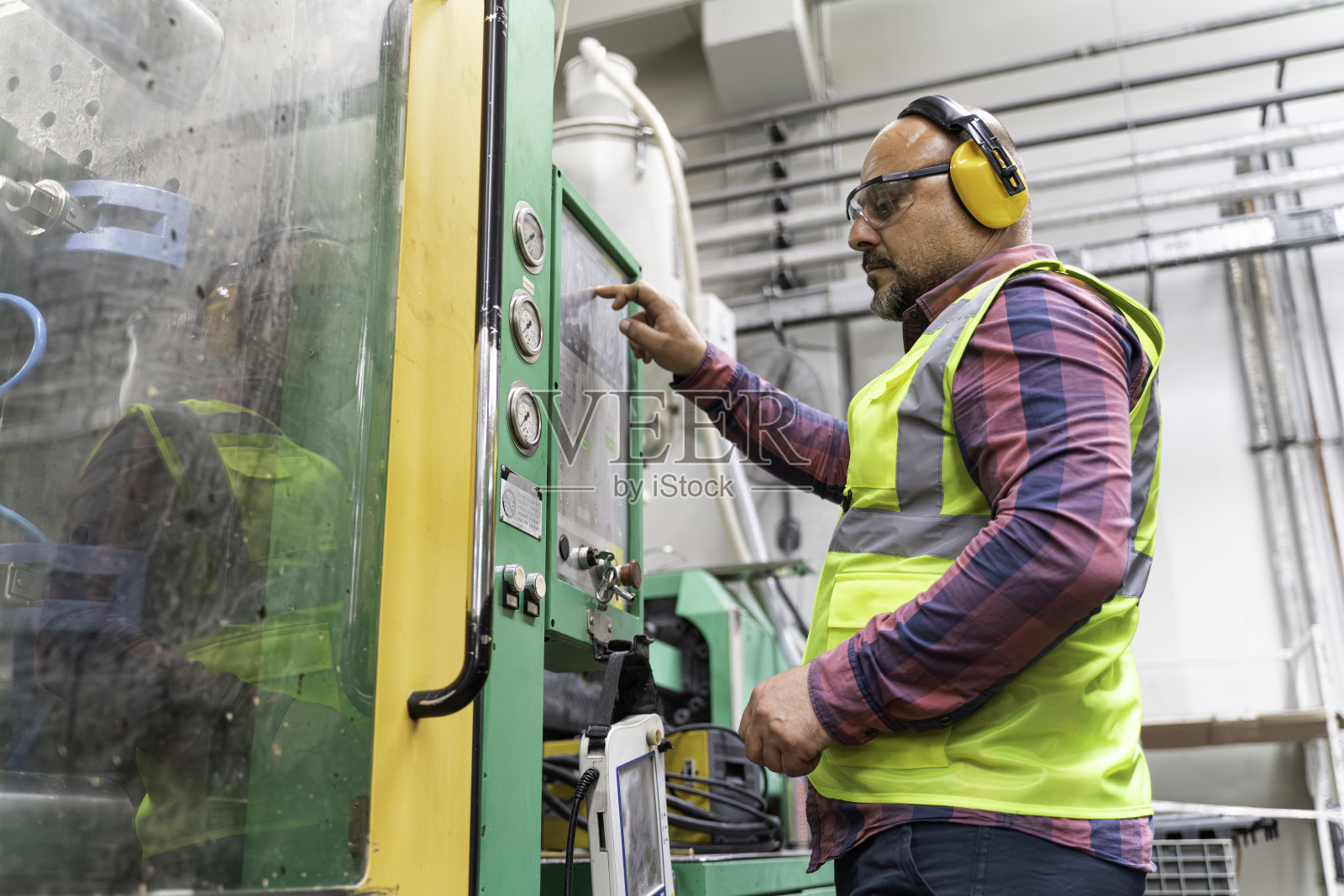 工厂里操作数控机床的男人照片摄影图片