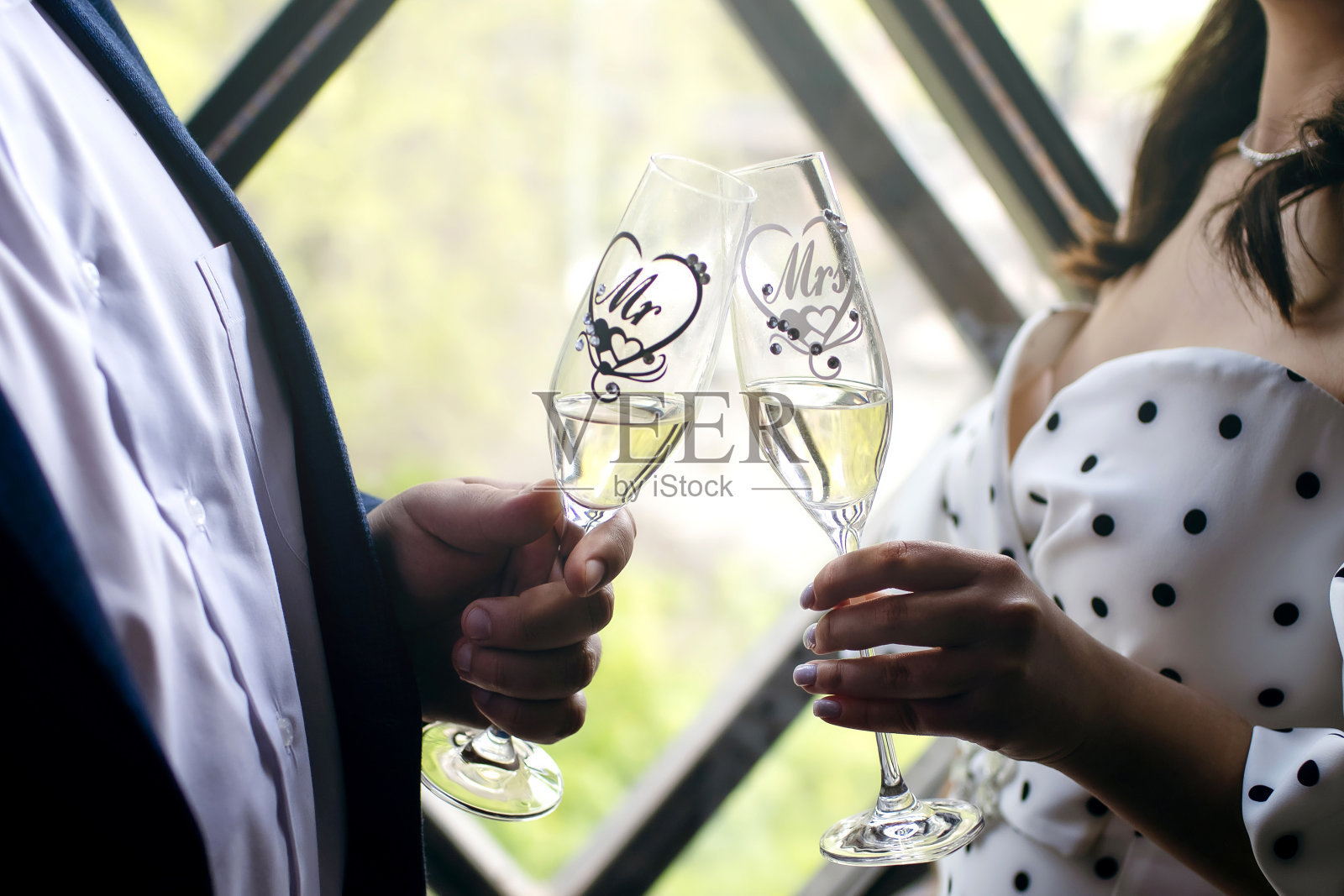 新娘新郎在窗边举杯香槟庆祝照片摄影图片