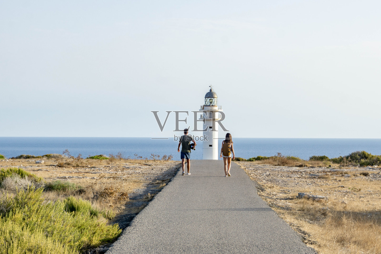 人们在海边散步，背对天空的后视图照片摄影图片