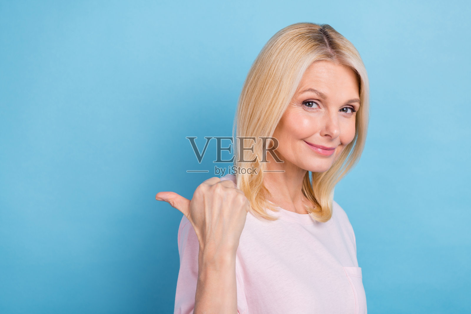 漂亮可爱的女士的肖像表明拇指手指空白的空间提供孤立的蓝色背景照片摄影图片