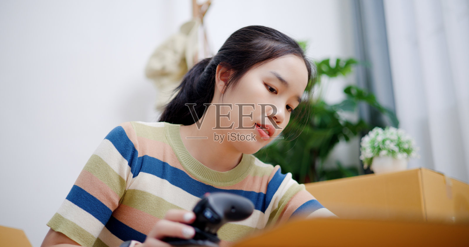 年轻女子把一个已经包装好的盒子合上。照片摄影图片