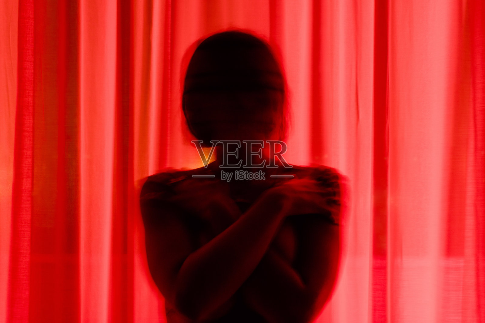 晚上躲在窗帘后面的无名之人照片摄影图片