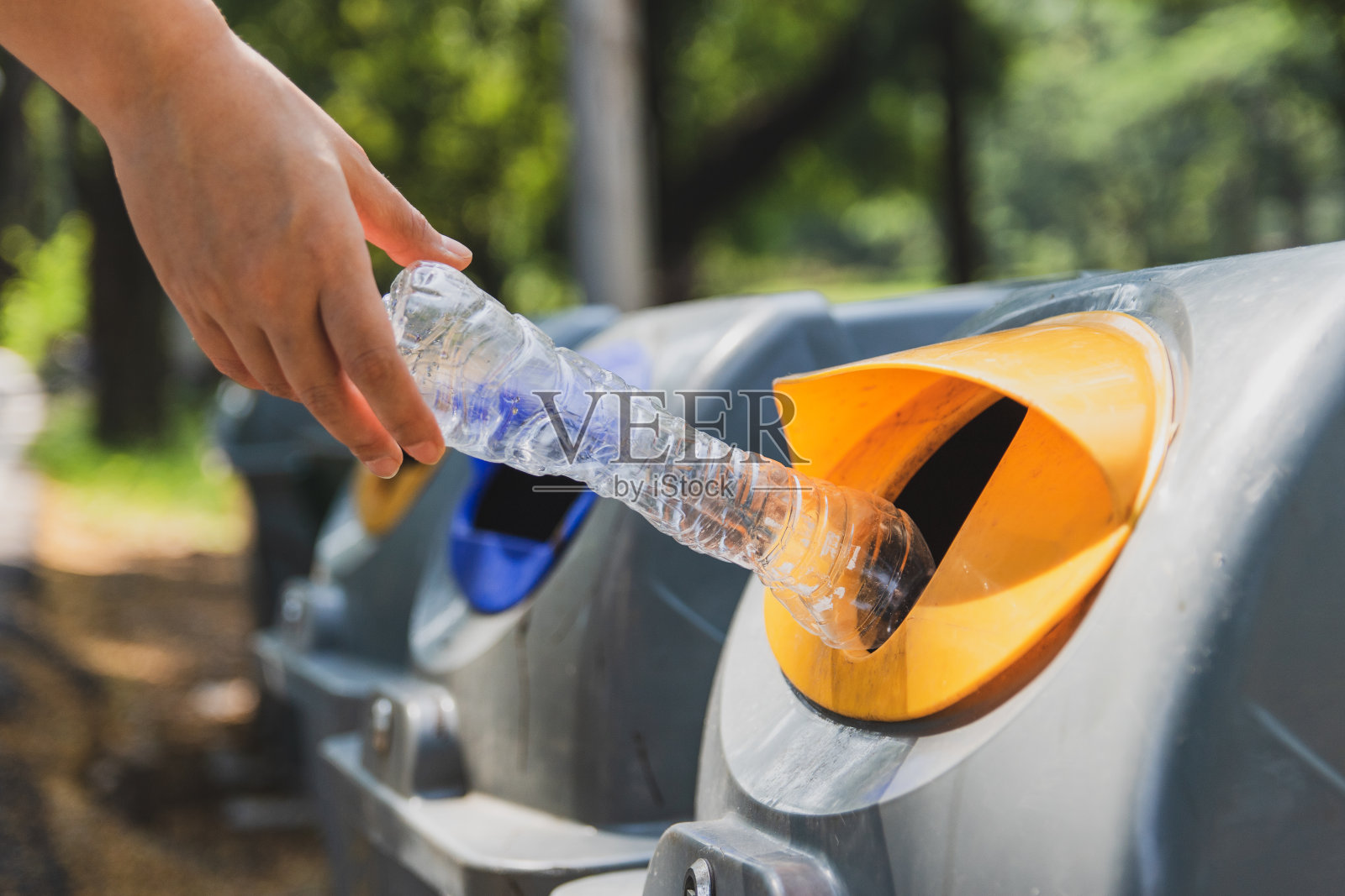 在垃圾桶中裁剪手处理水瓶照片摄影图片