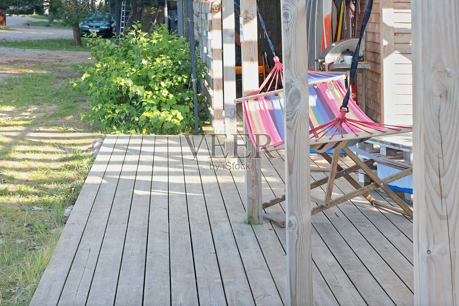 吊床在海边旧谷仓的木制露台上。照片摄影图片