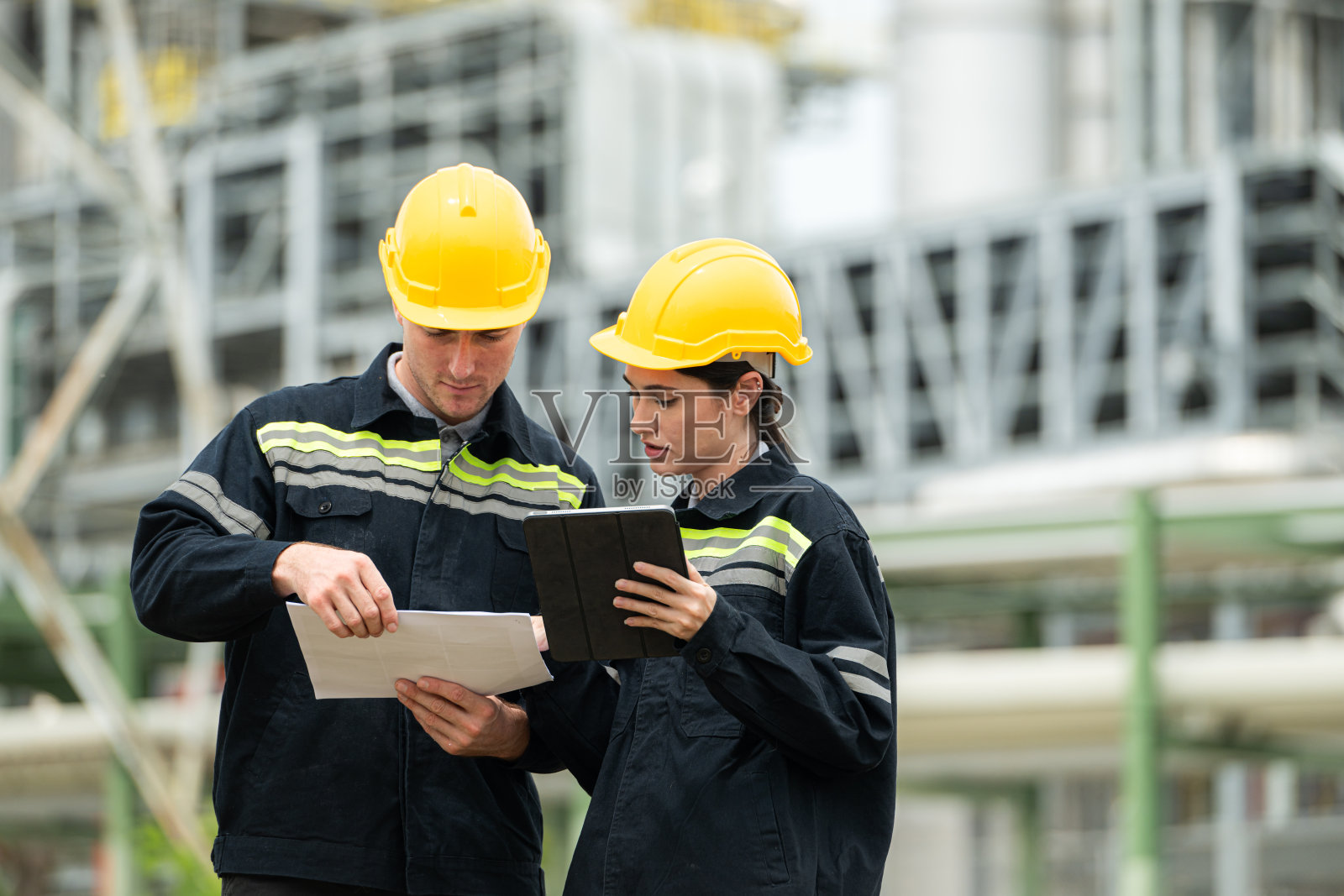 两位石油工程师都在一家大型炼油厂执行检查石油蒸馏的任务照片摄影图片