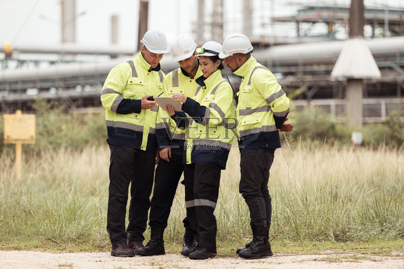 一群石油工程师正在一家大型炼油厂执行检查石油蒸馏的任务照片摄影图片