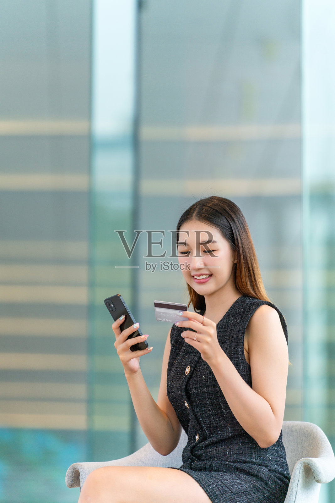 年轻女子使用手机及信用卡进行数码电子支付交易照片摄影图片