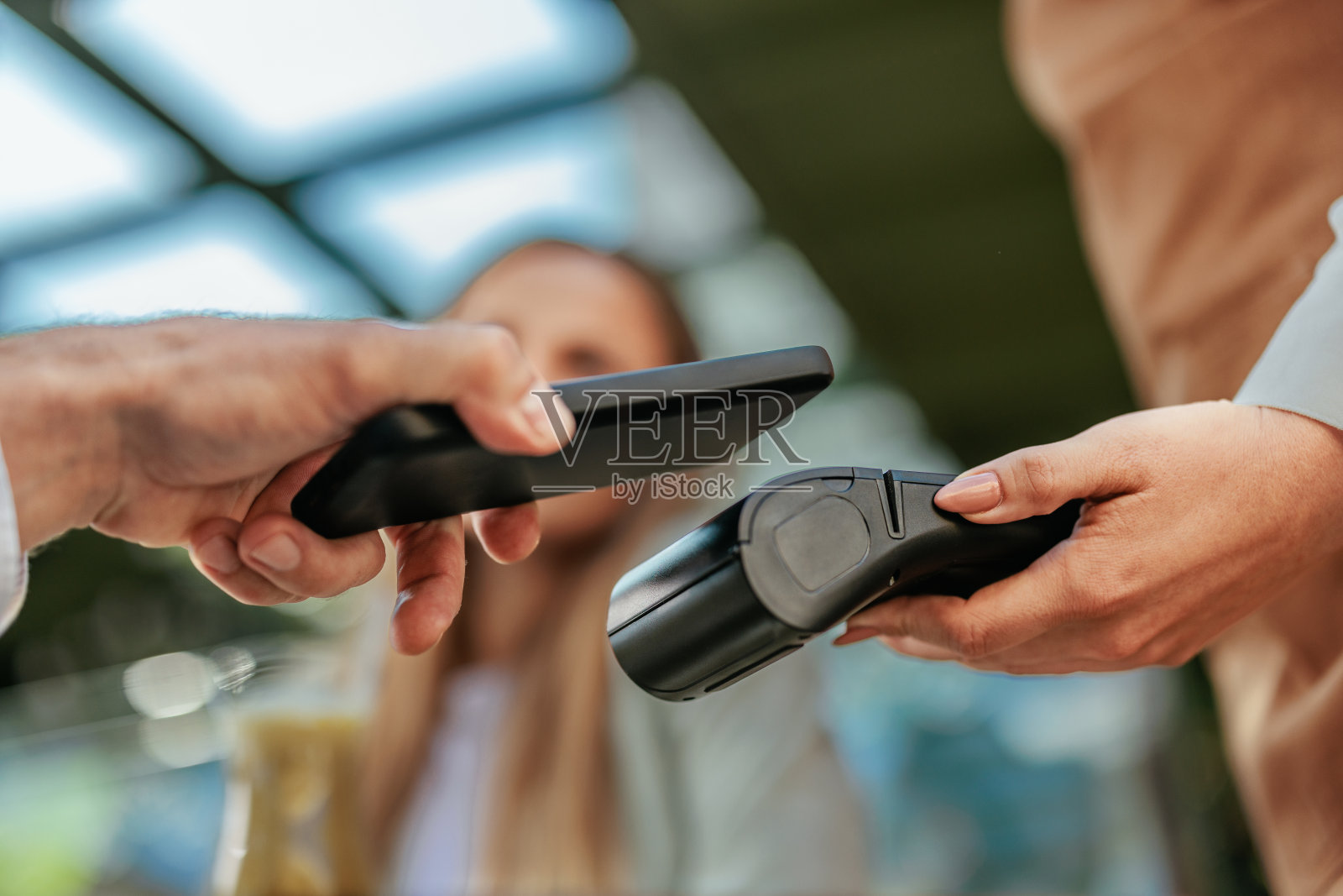 一名男子手持智能手机站在支付终端上照片摄影图片