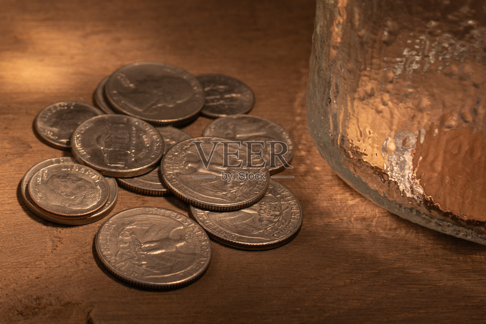 几个硬币旁边的空杯子在一个木制的背景。贫困的概念。文本复制空间照片摄影图片