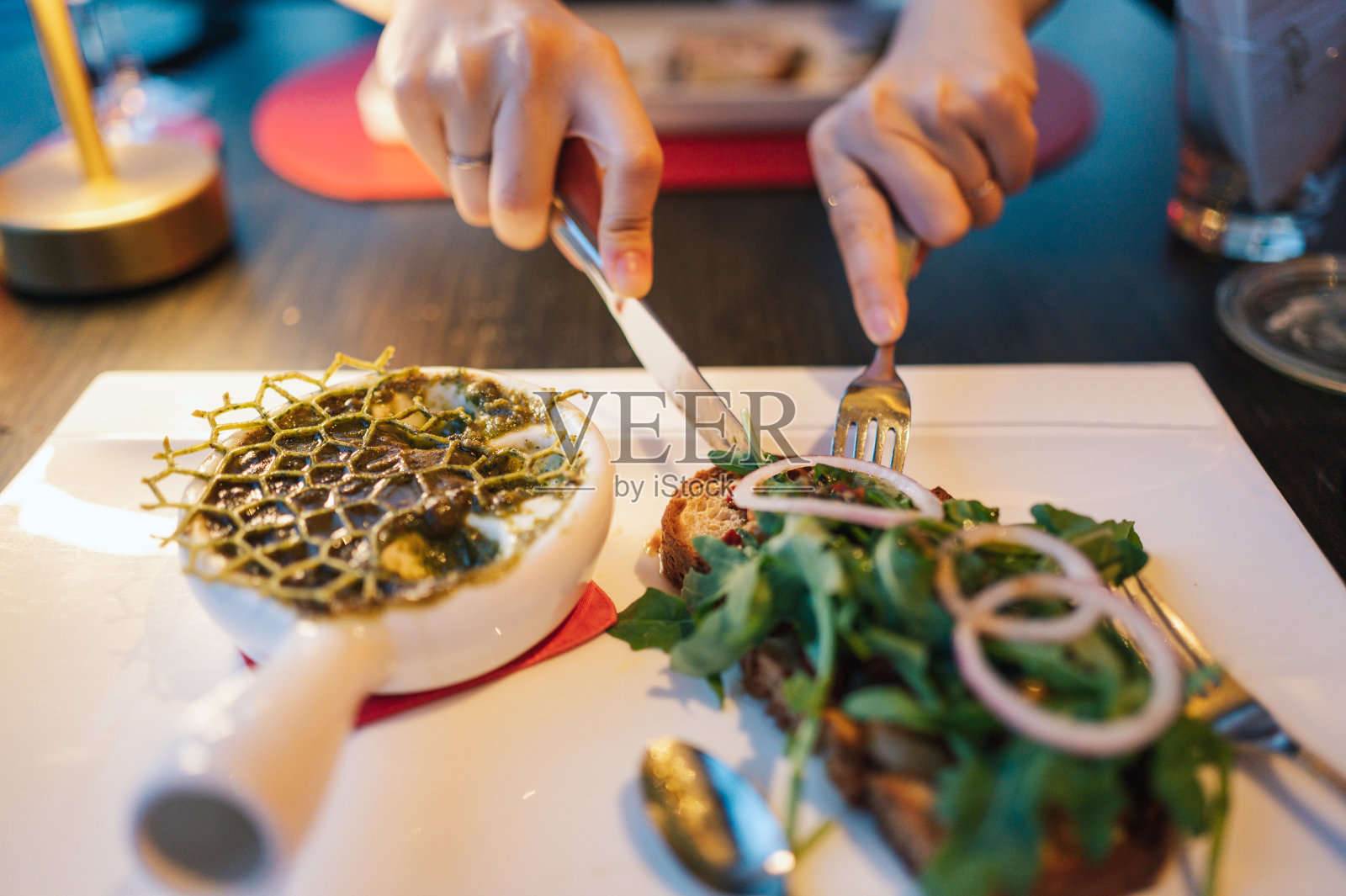 女士们享受用大蒜黄油酱炒蜗牛和骨髓的晚餐时间，烤骨髓和香草肉片照片摄影图片