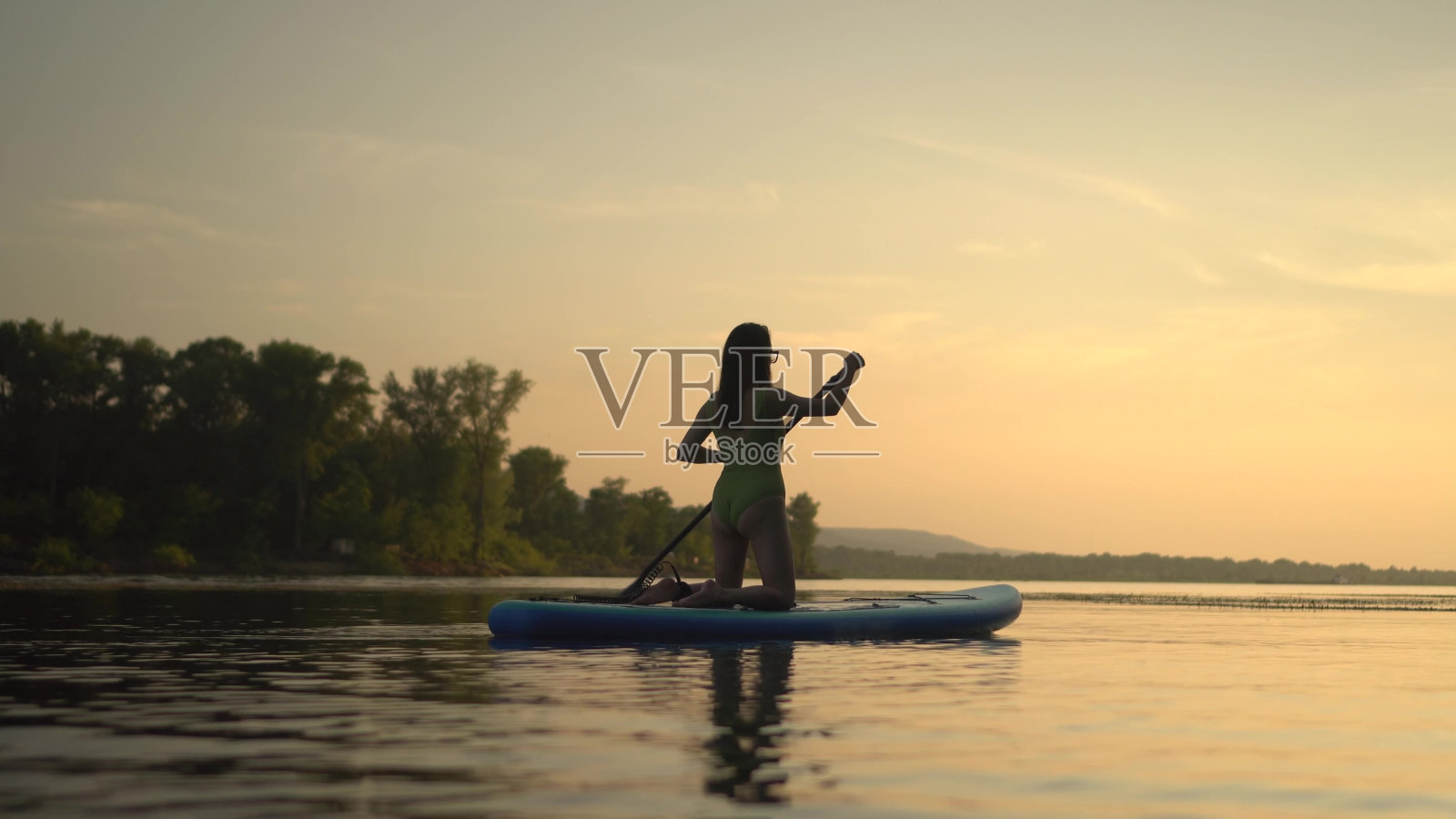 在一个风景如画的湖上享受一个宁静的黄昏，在日落时冲浪，这真的很迷人照片摄影图片
