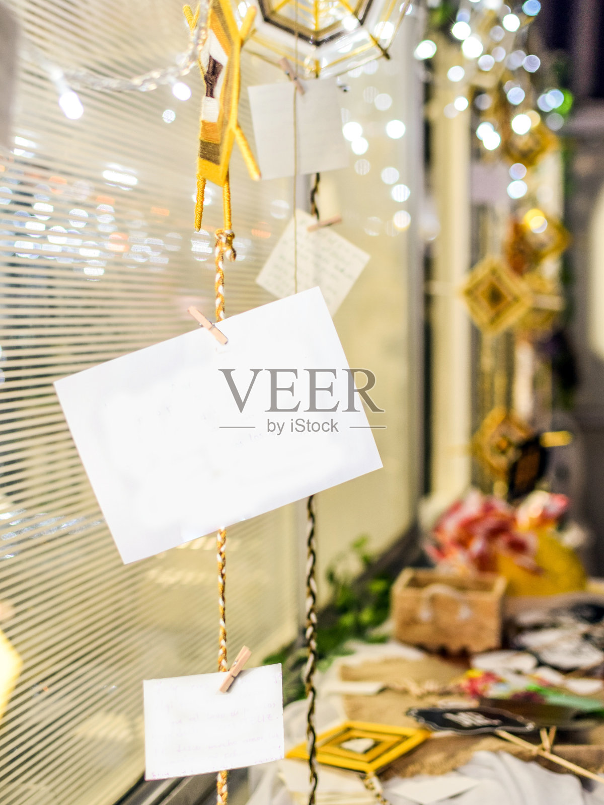 白色的纸上写着对新娘和新郎的爱和幸福的信息，用浅色的装饰悬挂在天花板上。照片摄影图片