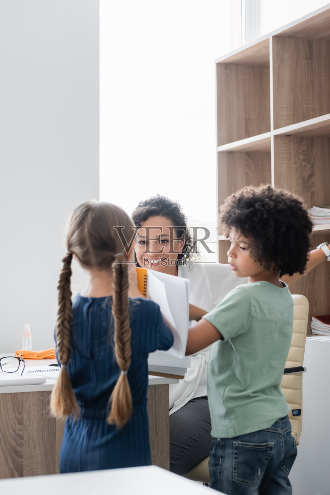 来自不同背景的快乐孩子和他们的非裔美国老师在课堂上照片摄影图片