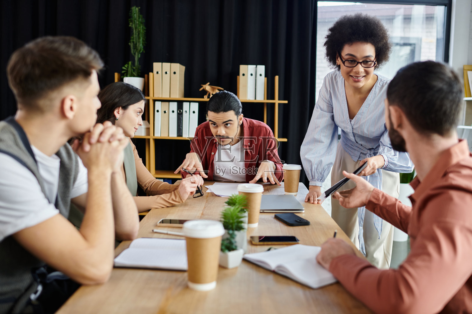 在现代办公环境中与多元文化专业人士进行充满活力的团队合作照片摄影图片