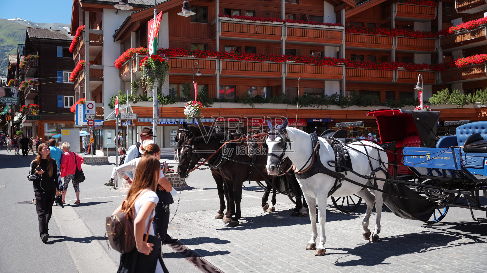 采尔马特繁忙的中央街道上,马车和行人在欣赏风景照片摄影图片