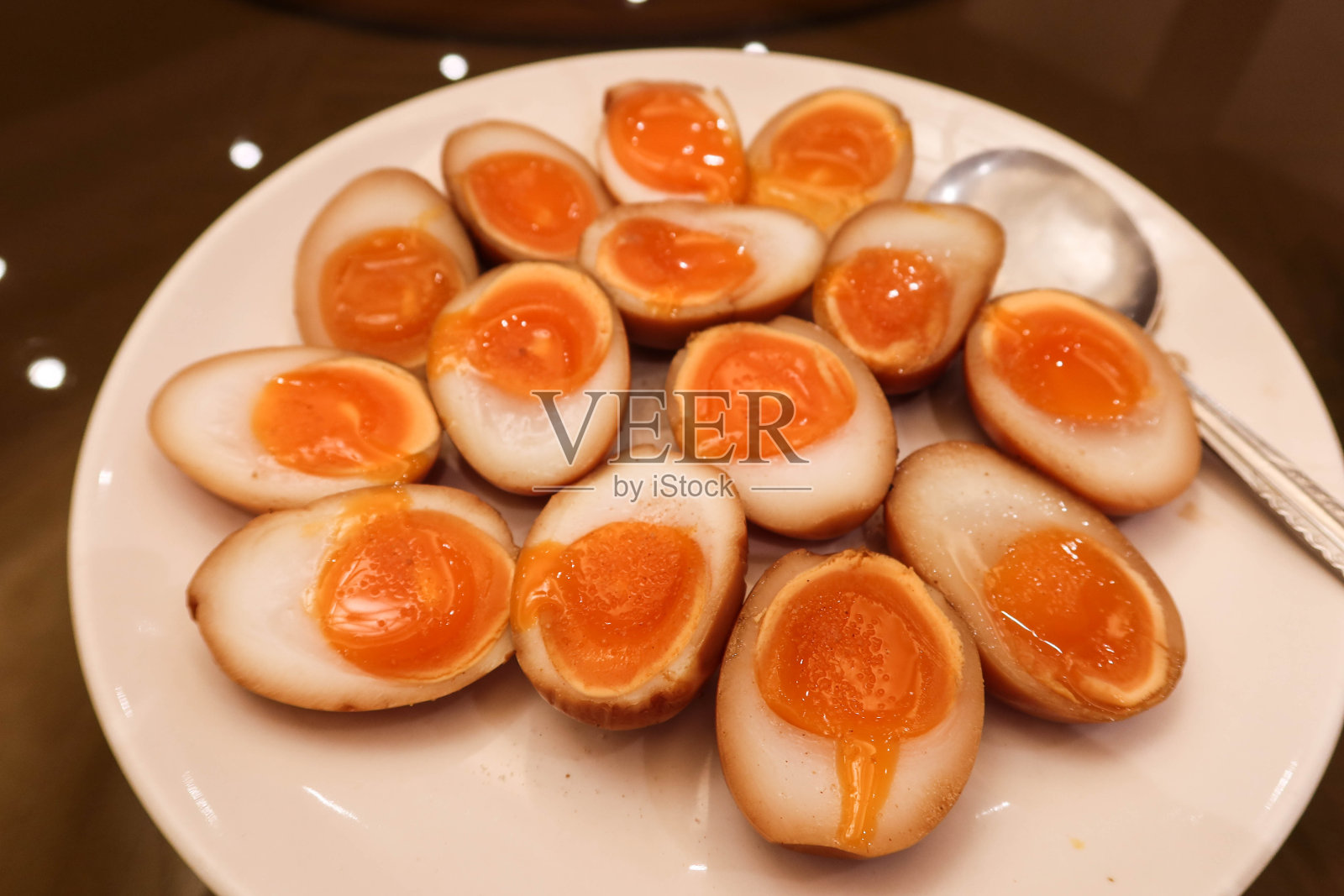 白色盘子里放着许多烟熏鸭蛋照片摄影图片