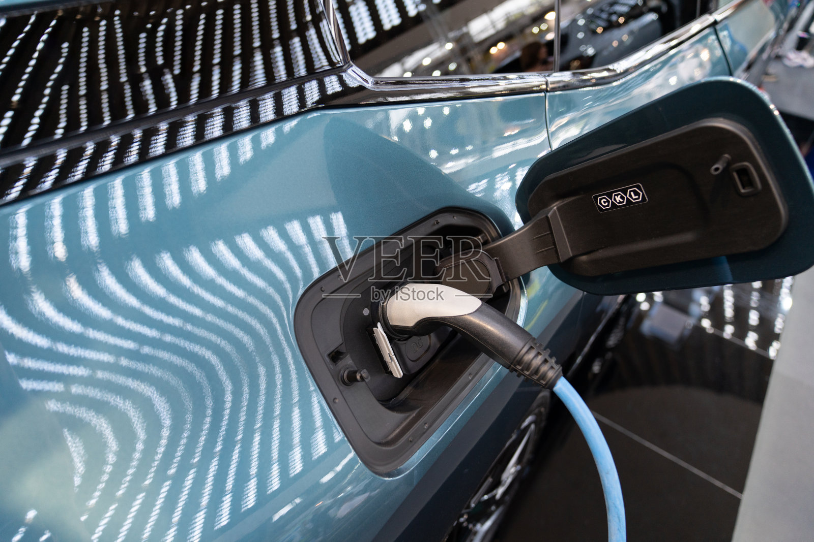 与充电电缆相连的电动汽车进气口特写照片摄影图片