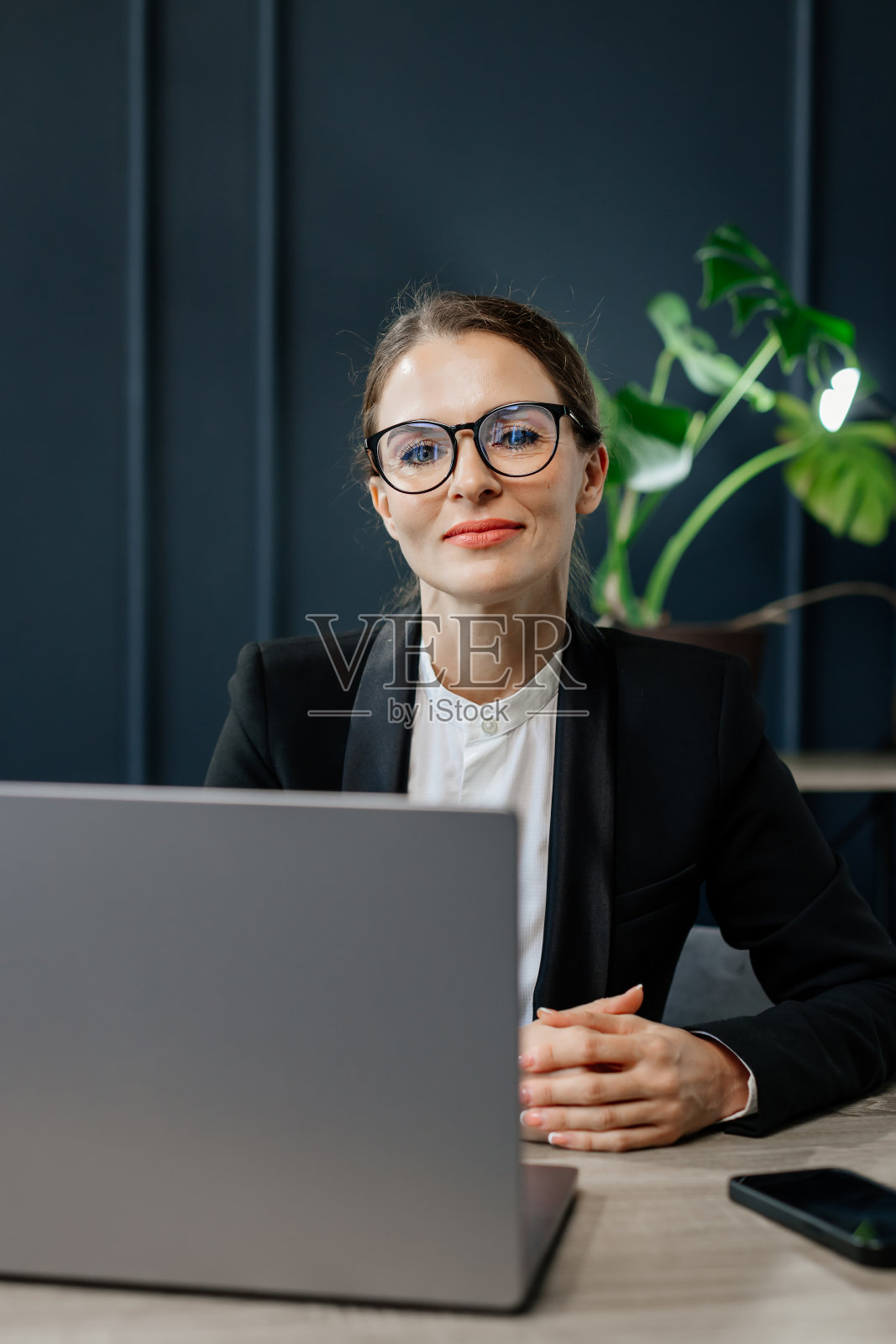 一位中年女商人，一位成功的导演，在她现代化的办公室里工作。非常适合领导力、成功和专业成就的主题。照片摄影图片