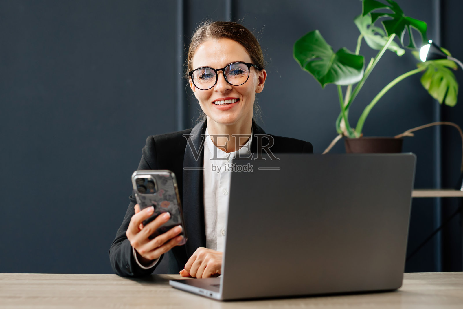 一位中年女商人，一位成功的导演，在她现代化的办公室里工作。非常适合领导力、成功和专业成就的主题。照片摄影图片