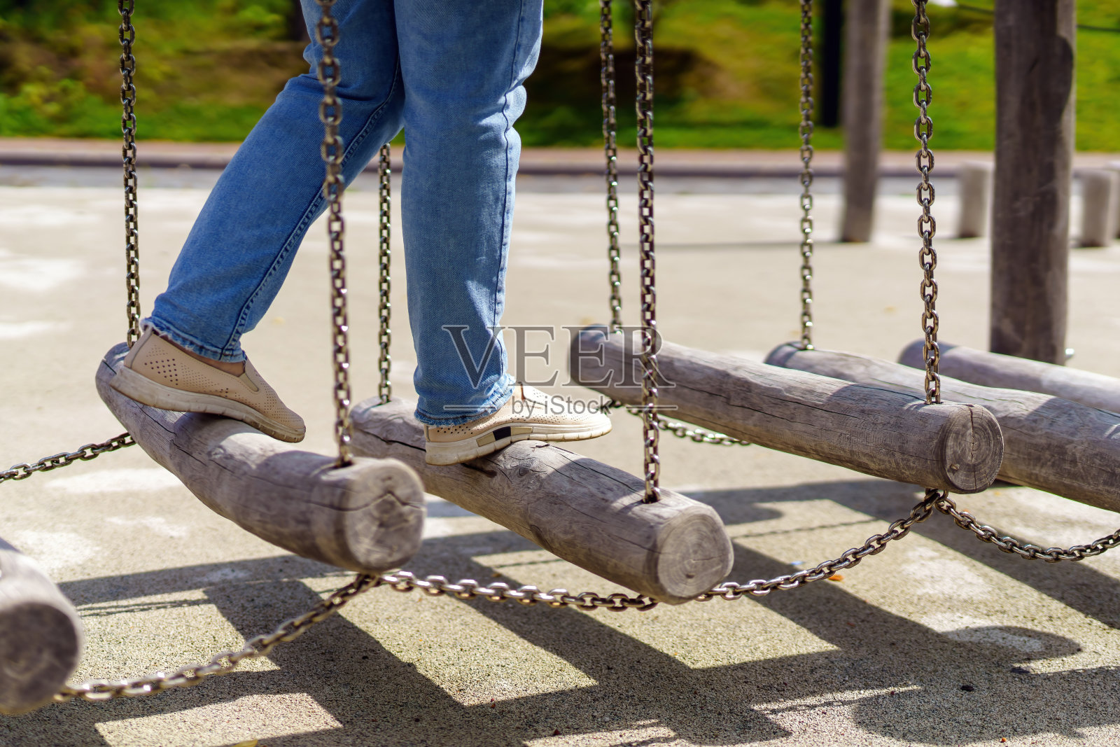 珀森驾驶着一种具有挑战性的健身器械:在动态的户外训练环境中，用金属链悬挂摆动的原木，展示平衡、力量和决心照片摄影图片