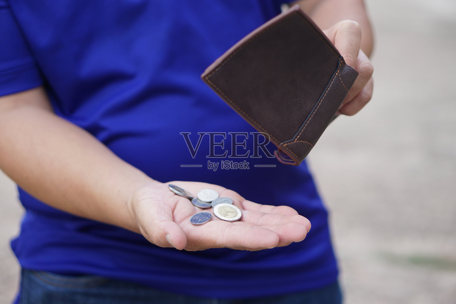 穷人手里拿着装有硬币的皮夹。经济不景气，金融危机，月末风险。财务管理。支付的一天。债务。坏了。破产。财务问题。照片摄影图片