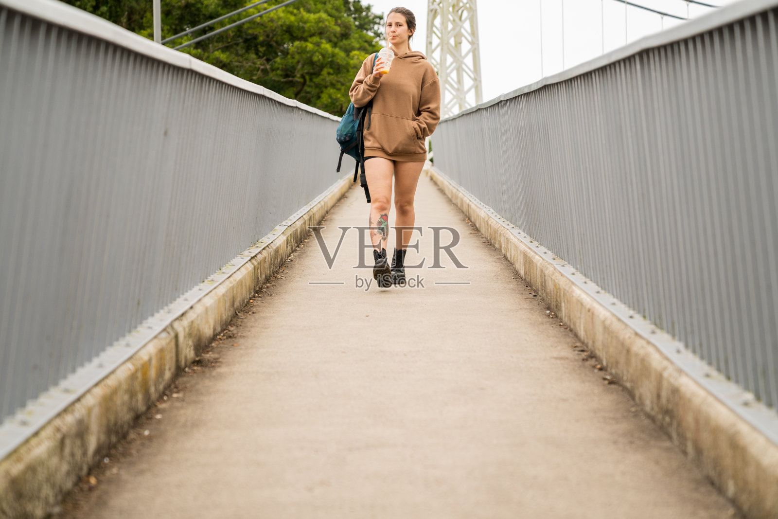 一个女人走下两边都有栏杆的斜坡。照片摄影图片