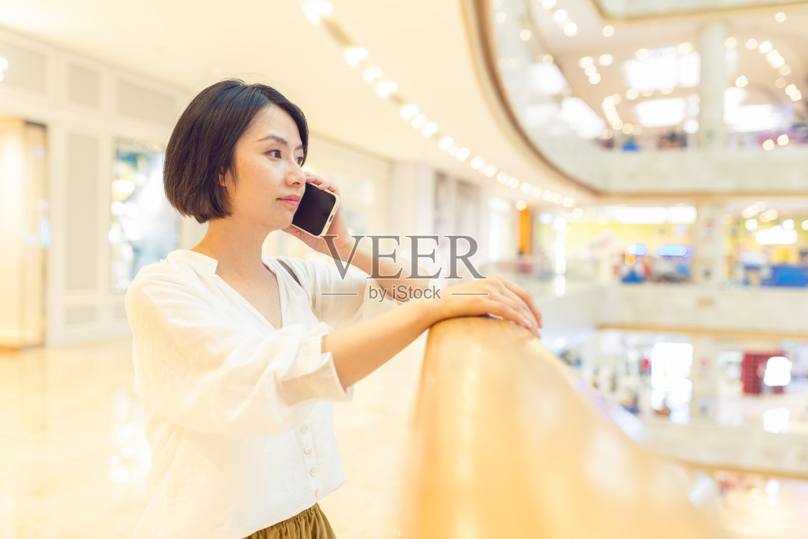 一位亚洲妇女在商场使用手机照片摄影图片