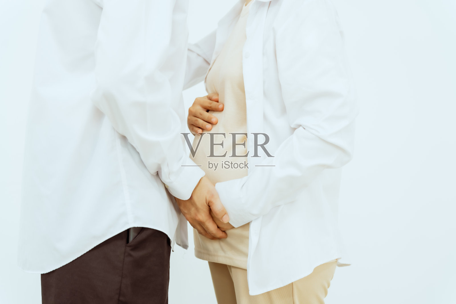 一对亚洲中年夫妇和怀孕的妻子深情地拥抱在一起，脸上洋溢着对即将到来的孩子的幸福和期待，象征着家庭的团聚和喜悦。照片摄影图片