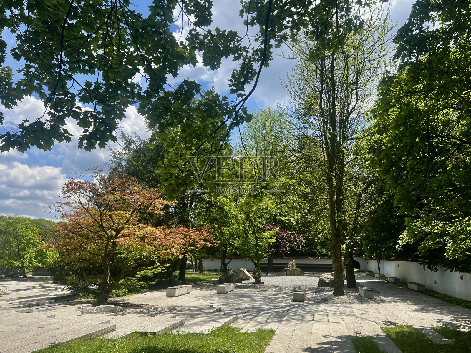 阳光明媚的日子里，波兰Chorzow公园里有石头走道和喷泉的花园照片摄影图片