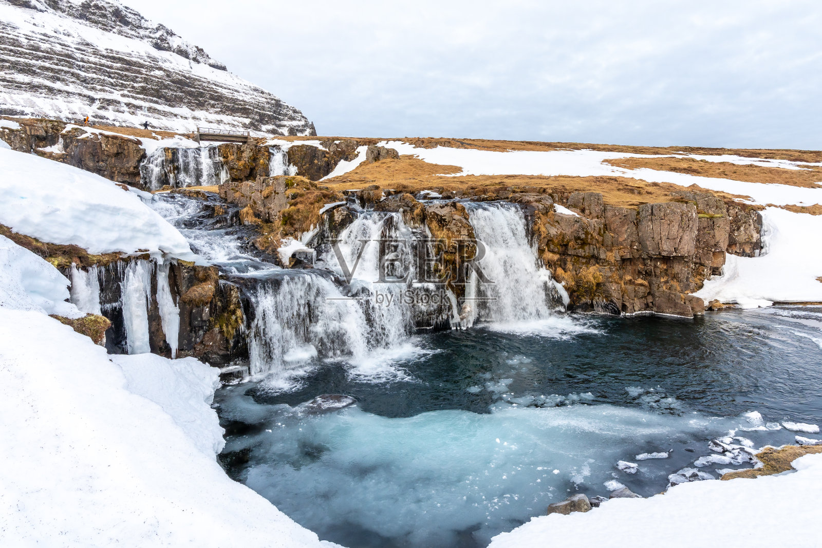 冬天，冰岛著名的Kirkjufell山上有美丽的瀑布和雪照片摄影图片