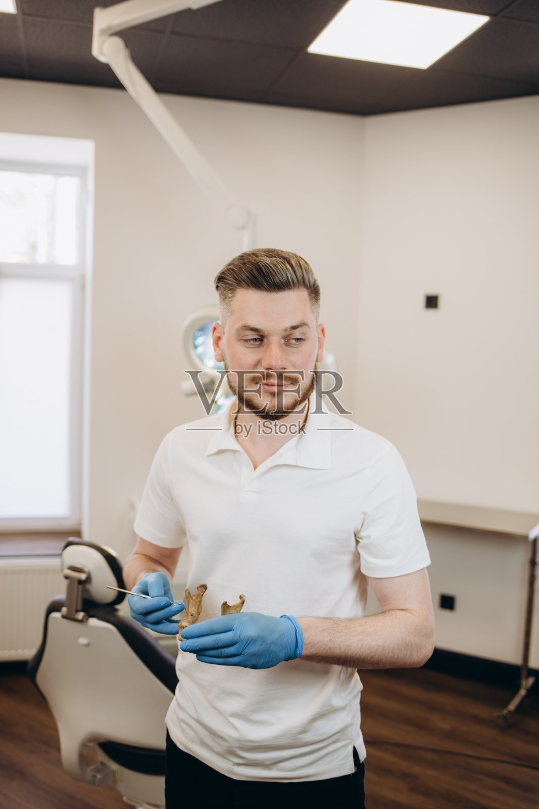 牙科诊所的数字屏幕上，戴着手套的牙医医生的手在x射线上显示牙齿照片摄影图片