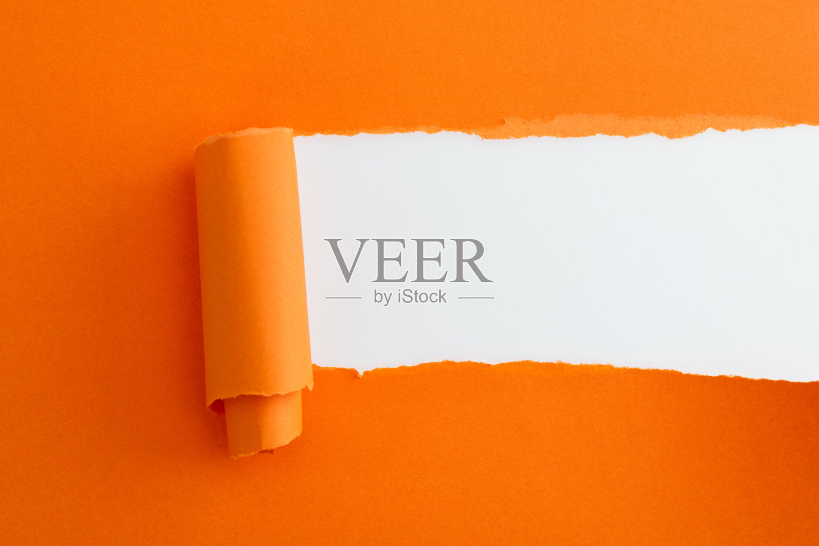 橙色的纸撕破了一个洞照片摄影图片
