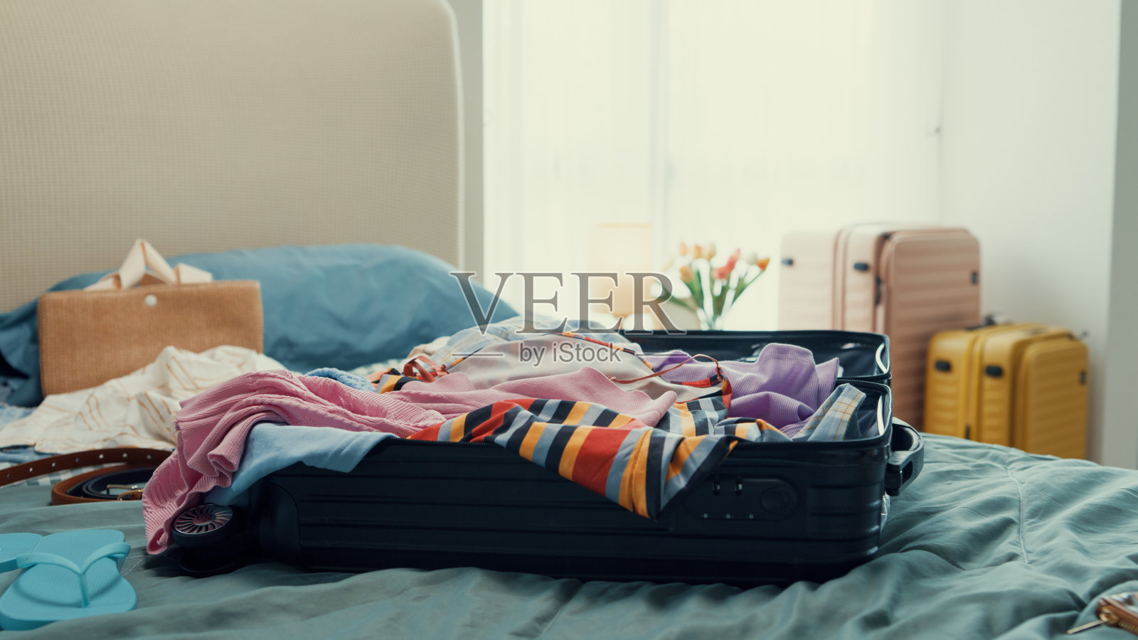 年轻的快乐和兴奋的亚洲女性准备暑假准备手提箱扔布配件凌乱的东西在包在卧室。为暑假旅行准备行李。照片摄影图片