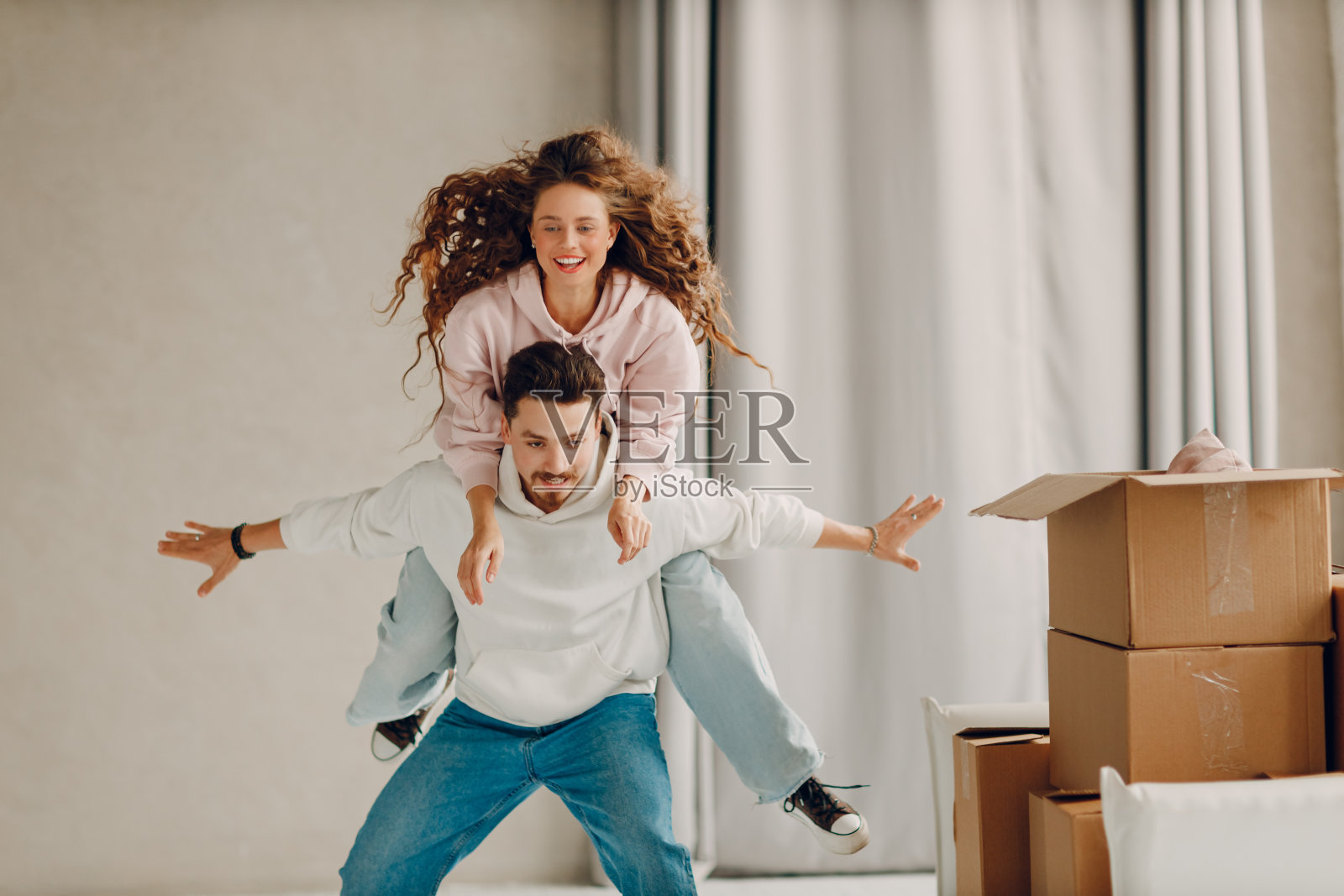 快乐的年轻家庭夫妇，男人和女人玩和享受后，移动纸板箱到新的房地产家庭公寓照片摄影图片