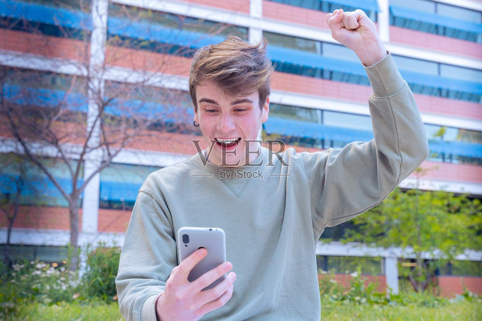 一个快乐的年轻人通过在线投注软件赢了。照片摄影图片