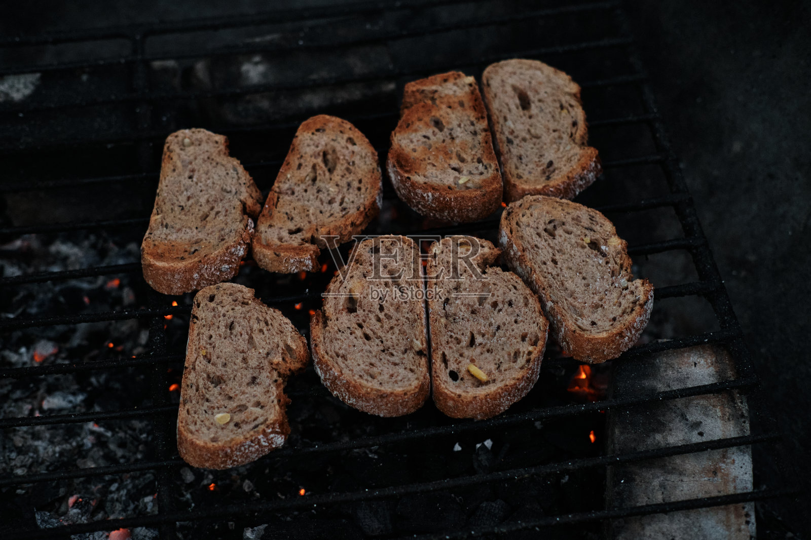 在户外烤架上烤的白面包。在外面野餐。面包片在煤上煎，近距离观察。照片摄影图片