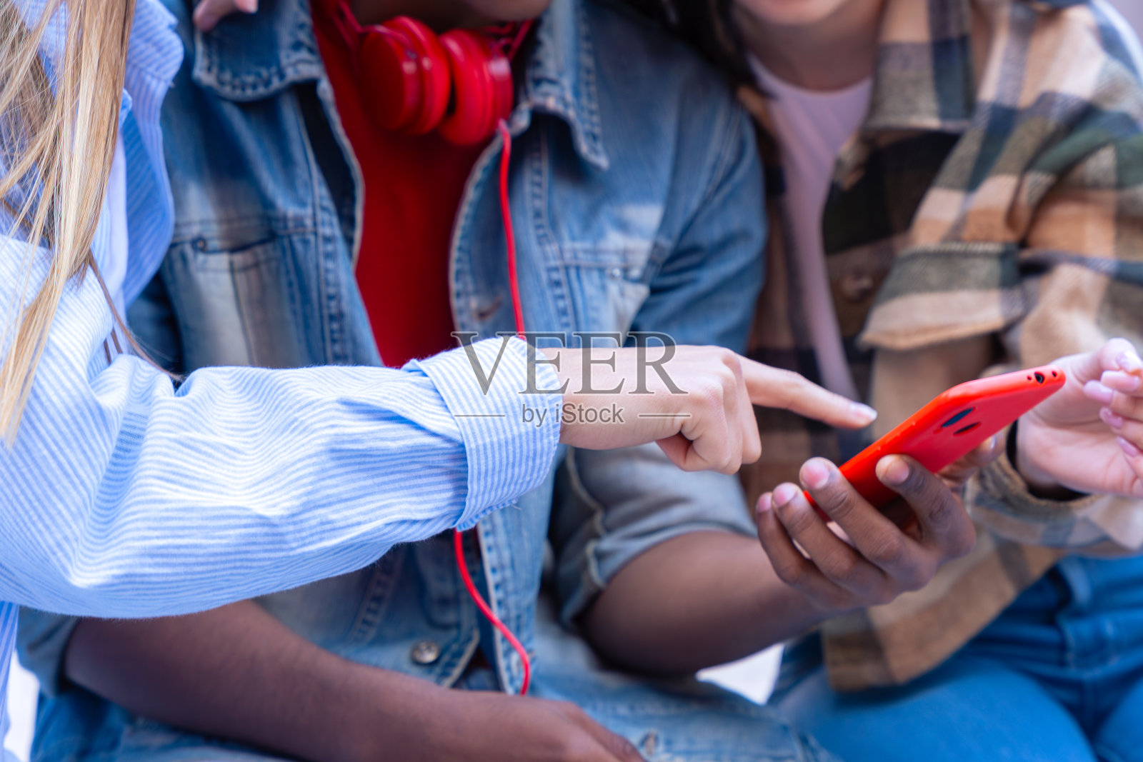 三个学生正在玩手机，在社交媒体上创作内容。照片摄影图片