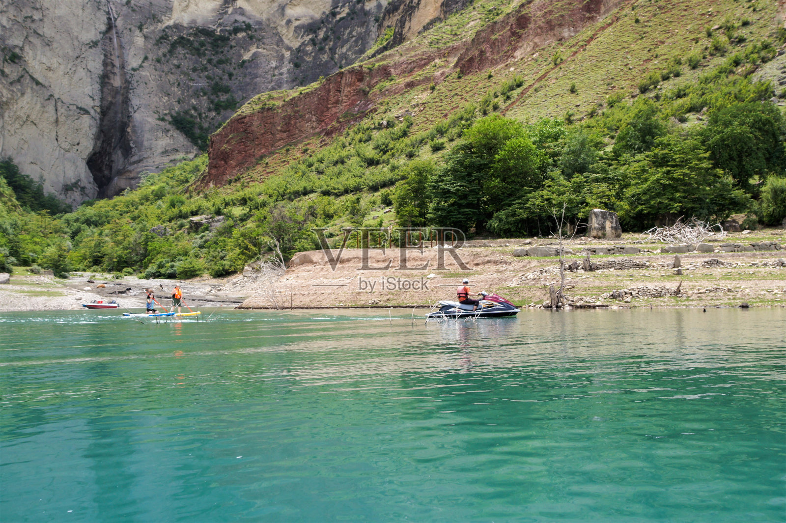 人们在靠近海岸的船上。照片摄影图片