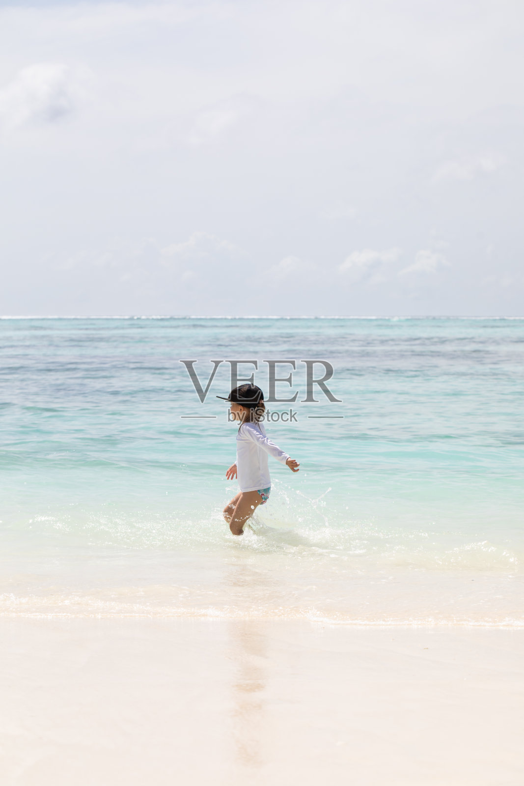 在海滩上快乐奔跑的年轻女孩，白色沙滩，儿童假期，夏季假期，碧绿的海水，岛屿度假照片摄影图片