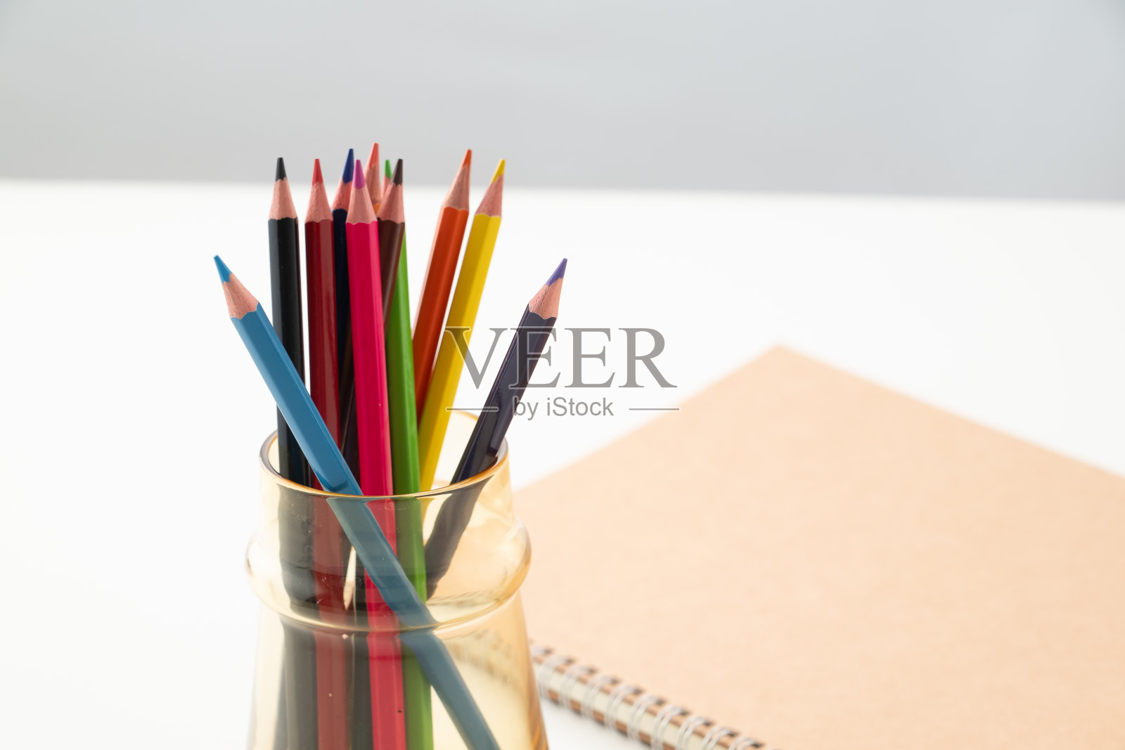 彩色铅笔和笔记本在白色的背景。照片摄影图片