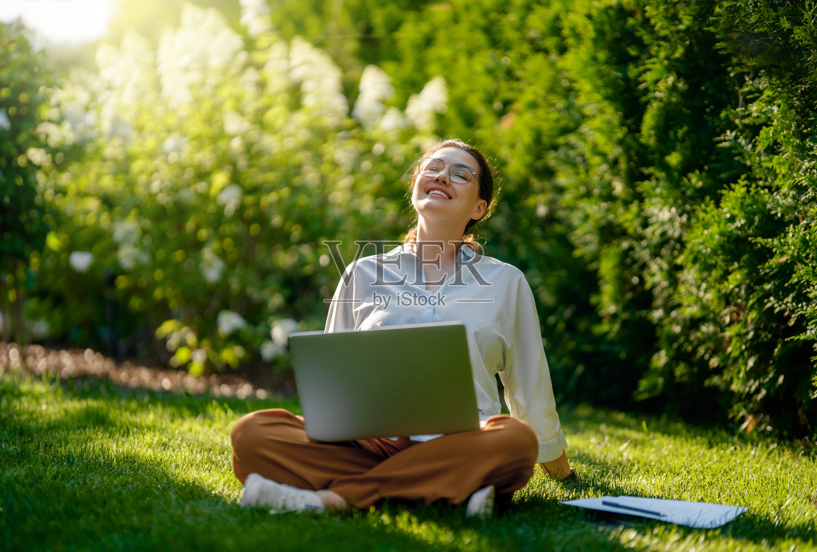 夏天的早晨，在笔记本电脑前工作的女人照片摄影图片