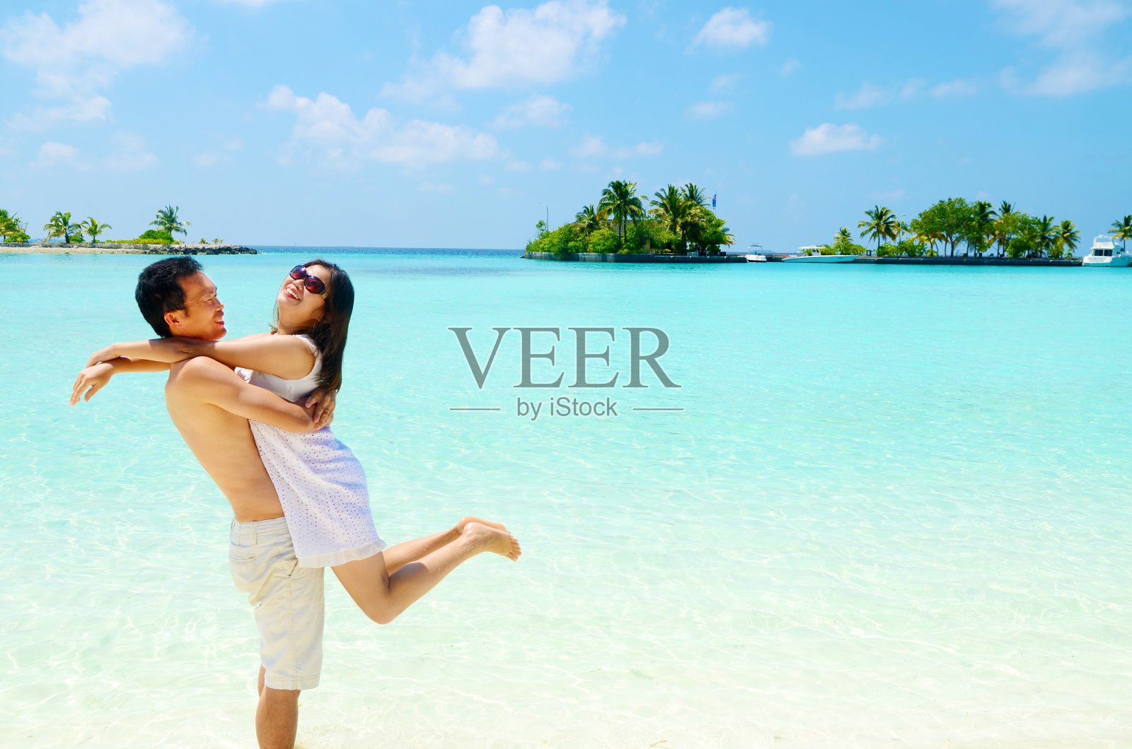 男人背着女人站在大海对着天空照片摄影图片